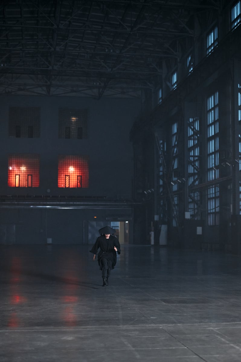 Person in Black Long Sleeve Shirt Walking on Gray Floor