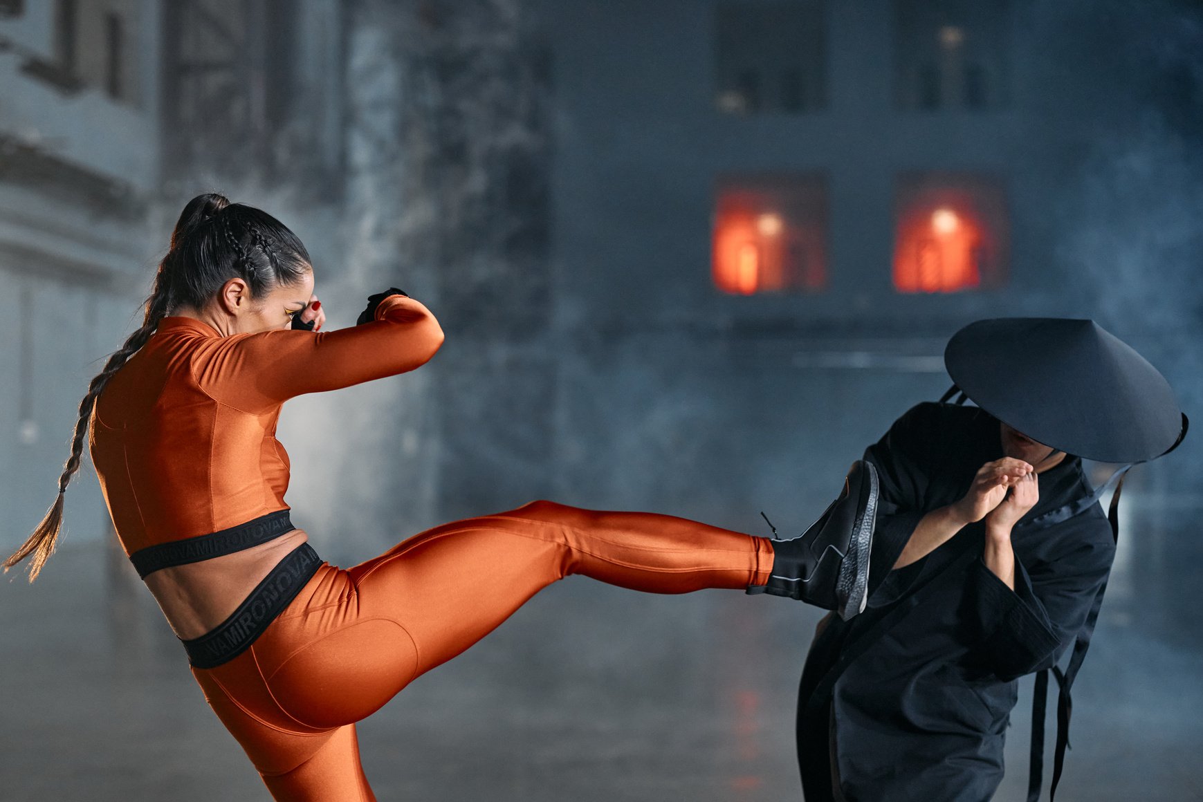 Woman in Orange and Black Body Suit and Black Pants